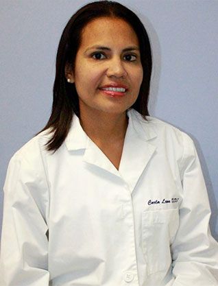 Carla Leon, DDS, dentist at Telegraph Dentists, standing in front of blue wall